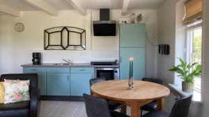 a kitchen and dining room with a table and chairs at Appartement Greidesicht Kollumerpomp in Kollumerpomp