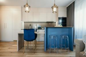 een keuken met blauwe barkrukken en een blauw eiland bij Apartament Talaso in Puck