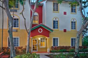 a house with a red and yellow facade at TownePlace Suites by Marriott Fort Lauderdale Weston in Weston
