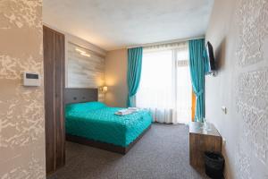 Un dormitorio con una cama verde y una ventana en Lecardo Hotel en Aheloy