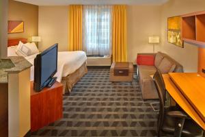 ウェストンにあるTownePlace Suites by Marriott Fort Lauderdale Westonのベッドとテレビが備わるホテルルームです。