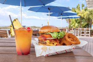 uma sanduíche e anéis de cebola e uma bebida na mesa em Marriott's SurfWatch em Hilton Head Island