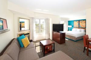 Habitación de hotel con sofá y cama en Residence Inn by Marriott Evansville East, en Evansville
