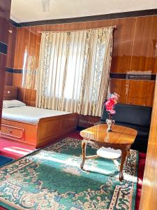 Cette petite chambre comprend un lit et une table. dans l'établissement Sudha’s Garden Home, à Katmandou