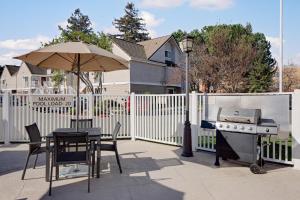 un patio con mesa, parrilla y sombrilla en Residence Inn Fremont Silicon Valley, en Fremont