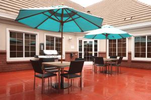 a patio with two tables and chairs with umbrellas at Residence Inn by Marriott Salinas Monterey in Salinas
