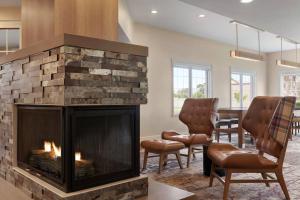 a living room with a fireplace and chairs at Residence Inn by Marriott Salinas Monterey in Salinas