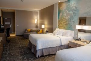 a hotel room with two beds and a couch at Courtyard by Marriott Omaha East/Council Bluffs, IA in Council Bluffs