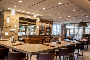 a bar in a restaurant with tables and chairs at Courtyard by Marriott Omaha East/Council Bluffs, IA in Council Bluffs