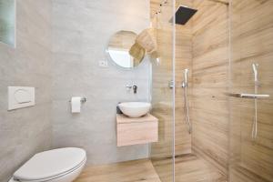 ein Badezimmer mit Toilette und Glasdusche in der Unterkunft Alto Apartments in Umag