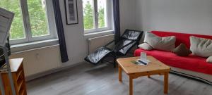 - un salon avec un canapé rouge et une table dans l'établissement Apartment-Hotel Schillerplatz, à Wittenberge