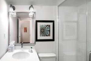 La salle de bains est pourvue d'un lavabo, de toilettes et d'une douche. dans l'établissement Four Points by Sheraton Manhattan, à Manhattan