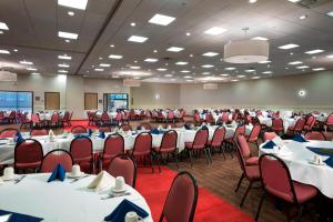 a banquet hall with white tables and red chairs at Four Points by Sheraton Manhattan in Manhattan