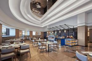 a restaurant with tables and chairs and a ceiling at Nanning Marriott Hotel in Nanning