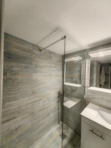 uma casa de banho com um chuveiro, um lavatório e um espelho. em Hermes - Acropolis Residence Apartment em Atenas