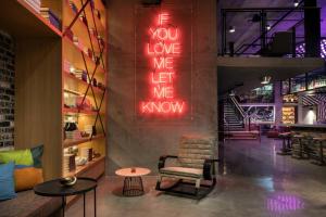 a room with a chair and a sign that says you love me let me know at Moxy San Diego Gaslamp Quarter in San Diego