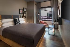 a bedroom with a bed and a desk and a window at Moxy San Diego Gaslamp Quarter in San Diego