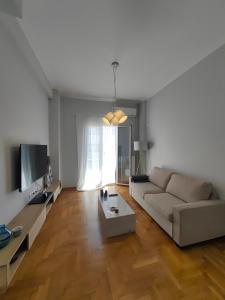 a living room with a couch and a tv at Hermes - Acropolis Residence Apartment in Athens