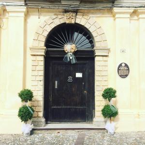 um edifício com uma porta preta com um arco em B&B Palazzo Pancaro em Altomonte