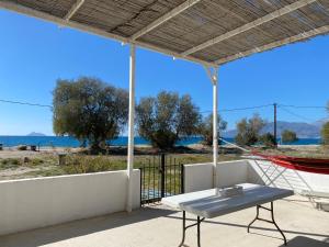 d'un patio avec une table et un hamac, ainsi que de la plage. dans l'établissement Zen Sea House 30m from the sea, à Kalamaki