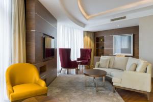 a living room with a couch and a table and chairs at Four Points by Sheraton Ikot Ekpene 