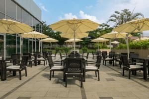 una fila di tavoli e sedie con ombrelloni di Four Points by Sheraton Ikot Ekpene a Ikot Ekpene