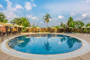 a swimming pool at a resort with tables and umbrellas at Four Points by Sheraton Ikot Ekpene 