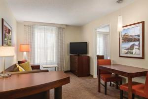 Habitación de hotel con escritorio y TV en Residence Inn by Marriott Newport Middletown, en Middletown