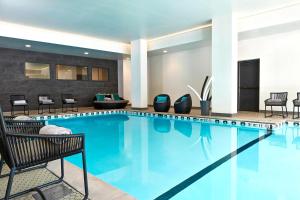 uma piscina num quarto de hotel com cadeiras e mesas em Residence Inn Minneapolis Downtown at The Depot em Minneapolis