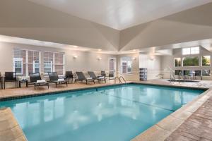 a large swimming pool with lounge chairs and tables at Residence Inn by Marriott Newport Middletown in Middletown