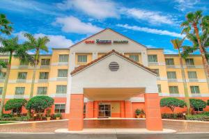 a hotel building with palm trees in front of it at Fairfield Inn & Suites By Marriott Jupiter in Jupiter