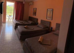 a hotel room with three beds and a couch at Guest House Green Garden in Ulcinj