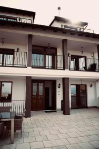ein Gebäude mit einer Terrasse und einem Tisch davor in der Unterkunft Kalaja Apartment in Prizren