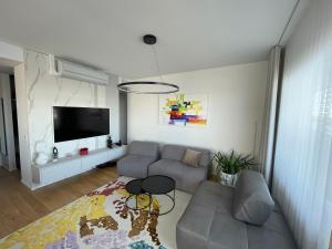 ein Wohnzimmer mit einem Sofa und einem TV in der Unterkunft Rannakivi Penthouse in Pärnu