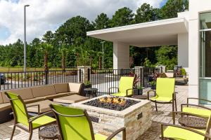 eine Terrasse mit Stühlen und einer Feuerstelle in der Unterkunft SpringHill Suites by Marriott Savannah Richmond Hill in Richmond Hill
