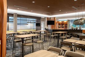 a restaurant with tables and chairs and a bar at SpringHill Suites by Marriott Savannah Richmond Hill in Richmond Hill