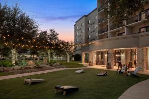 un patio de un edificio con bancos en el césped en Courtyard by Marriott San Antonio Six Flags at The RIM, en San Antonio