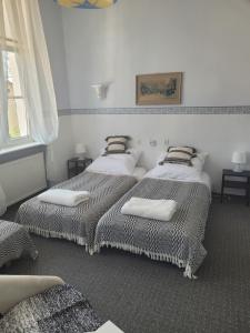 three beds in a room with white walls and a window at Agroturystyka "Pałac w Janowie" in Janów +114 photos