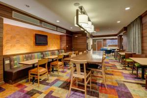 comedor con mesas y sillas y TV en Fairfield Inn and Suites by Marriott Potomac Mills Woodbridge, en Woodbridge