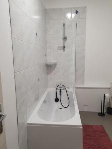 bagno bianco con doccia e vasca di Appartement neuf, très lumineux a Hautot-sur-Mer