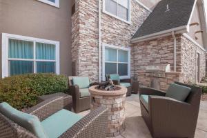 eine Terrasse mit Korbstühlen und einer Feuerstelle in der Unterkunft Residence Inn by Marriott San Antonio North Stone Oak in San Antonio
