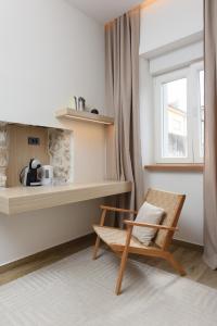 a wooden chair in a room with a window at NEW!Beautiful modern bedrooms and apt Old town Zadar- Great location in Zadar