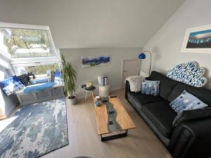 uma sala de estar com um sofá preto e uma mesa em River Vista Retreat - Luxury duplex Apt - Views - Parking - Cycle storage - Spa access option em Backbarrow