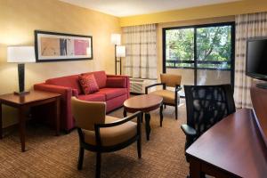 um quarto de hotel com um sofá e cadeiras e uma televisão em Courtyard Costa Mesa South Coast Metro em Santa Ana