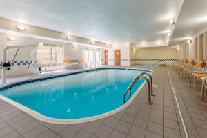 una piscina en una habitación de hotel con sillas alrededor en Fairfield Inn & Suites Stevens Point, en Stevens Point