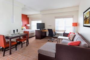 a hotel room with a couch and a bed and a desk at Residence Inn by Marriott Bloomington by Mall of America in Bloomington