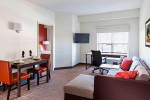 Residence Inn by Marriott Bloomington by Mall of America في بلومنغتون: غرفة معيشة مع أريكة وطاولة