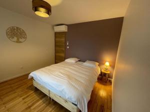 1 dormitorio con 1 cama blanca en una habitación en Gîte La perle d’Alsace, en Bernardswiller