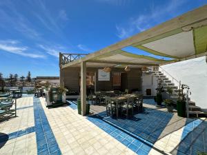 un patio con mesas y sillas y un edificio en Mama Souiri Hotel, en Essaouira