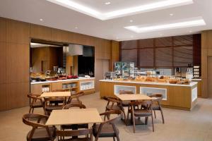 a dining room with tables and a kitchen at Fairfield by Marriott Busan in Busan